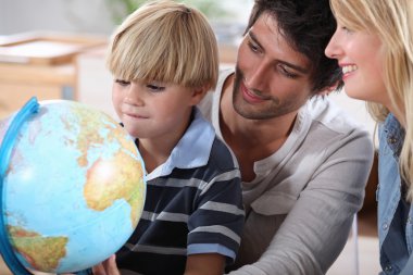 Little boy learning about the world with the help of his parents clipart