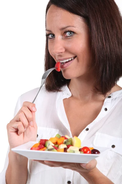 Жінка середнього віку їсть фруктовий салат — стокове фото