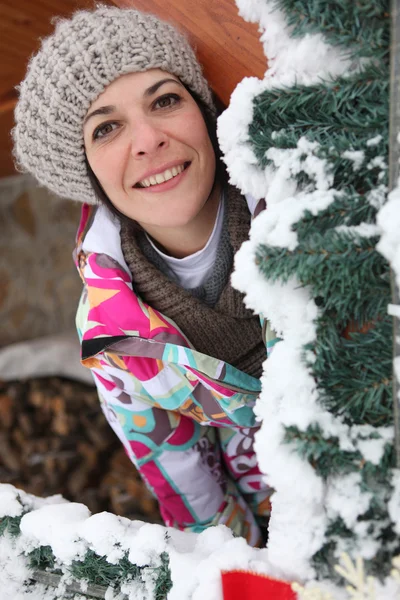 Donna dietro l'albero nevoso — Foto Stock