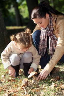 Mother and daughter picking mushrooms clipart