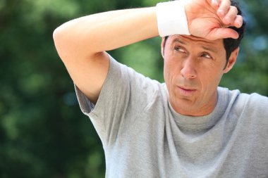 Man wiping sweat from his brow clipart