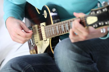 Closeup of a man playing a guitar clipart