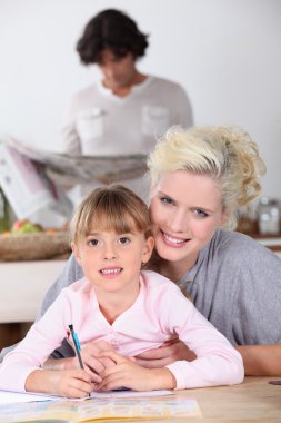 Mother with girl doing homework clipart