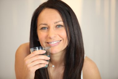 Brunette woman with glass of water clipart