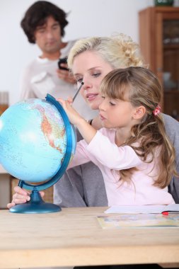 Mother and daughter looking at globe clipart