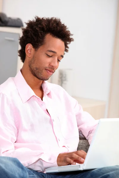 Tjej med lockigt hår tittar på en dator — Stockfoto