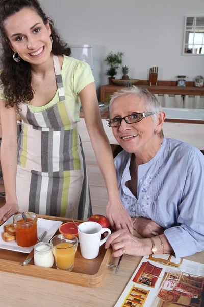 Seniorin bekommt Frühstück zu Hause serviert — Stockfoto