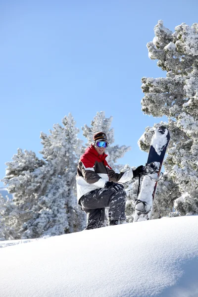 Muž stál na vrcholu hory s snowboardu — Stock fotografie
