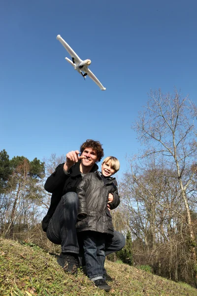 Батько і син грають з літаком — стокове фото