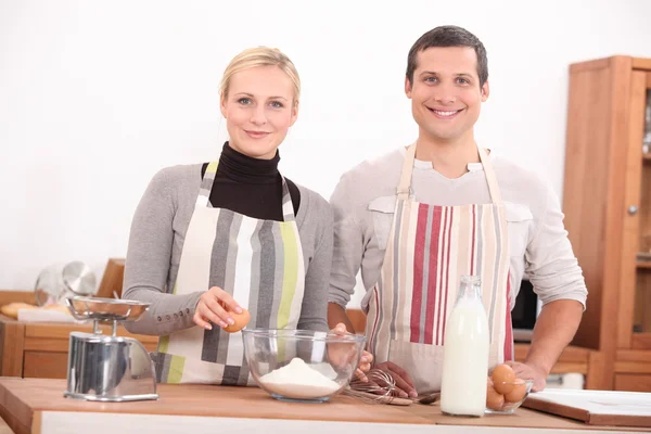 Lycklig man och kvinna förbereda en kaka — Stockfoto