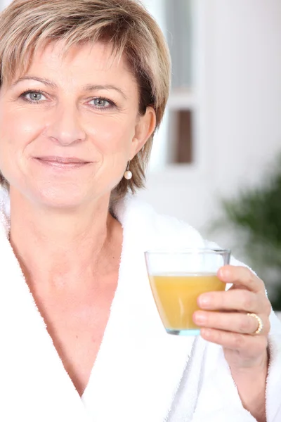 Volwassen vrouw drinken sinaasappelsap — Stockfoto