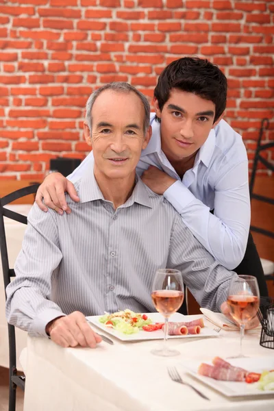 Отец и сын обедают вместе в ресторане — стоковое фото