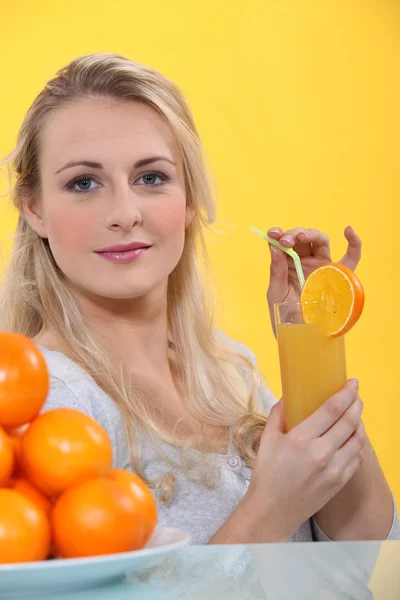 Ξανθιά γυναίκα με χυμό πορτοκάλι — Φωτογραφία Αρχείου
