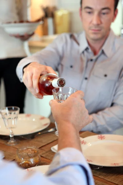 Mann schenkt Wein während des Essens ein — Stockfoto