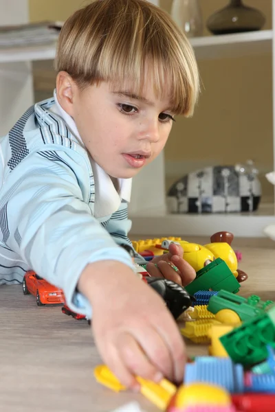 Молодий хлопчик грає з іграшками — стокове фото