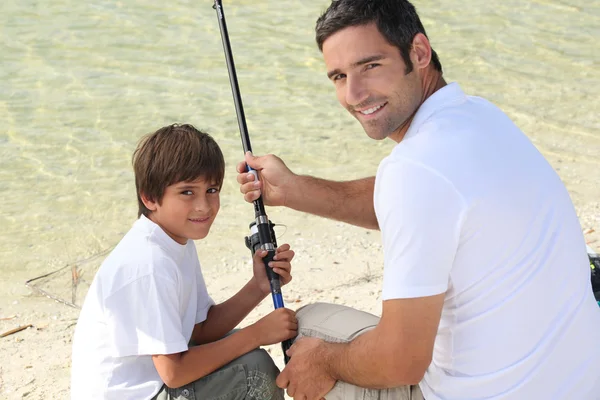 Little boy fishing with his dad — Stock Photo, Image