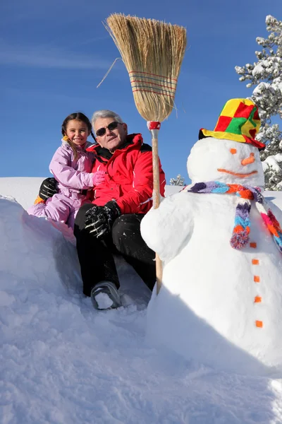 Grand-père posant avec sa petite-fille à la station de ski — Photo