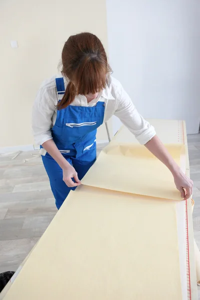 Frau legt Tapetenblätter aus — Stockfoto