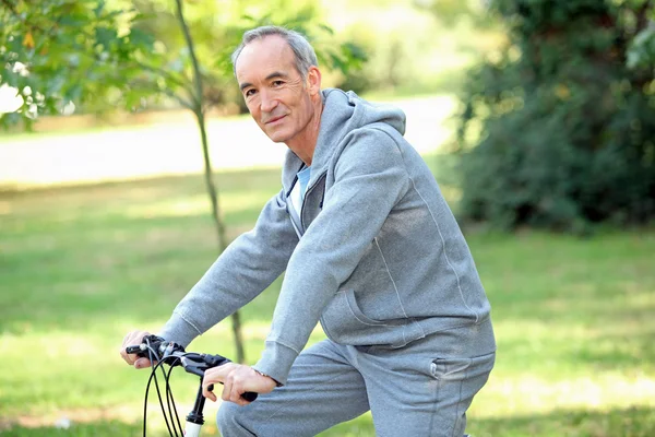 Äldre man ridandes på sin cykel — Stockfoto