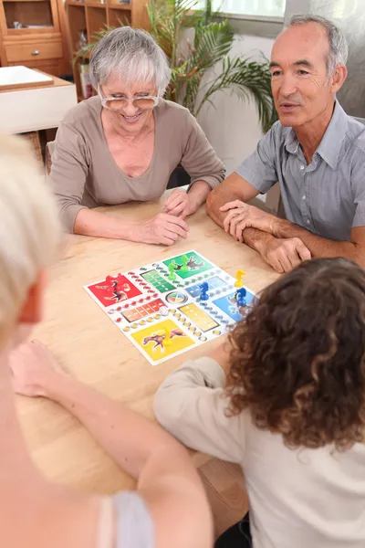 Familj spelar brädspel tillsammans — Stockfoto