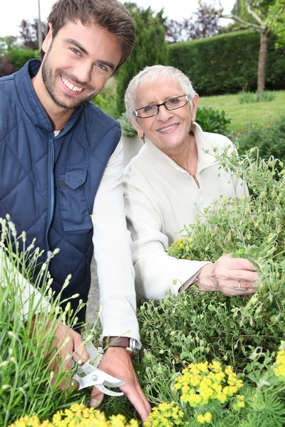 Donna anziana con un giovane giardiniere — Foto Stock