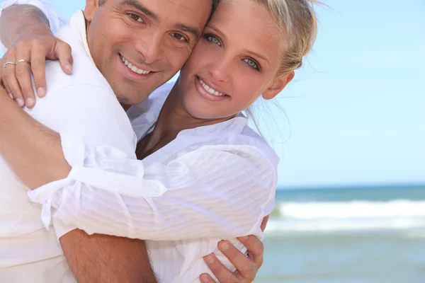 Paar omhelzingen op het strand — Stockfoto