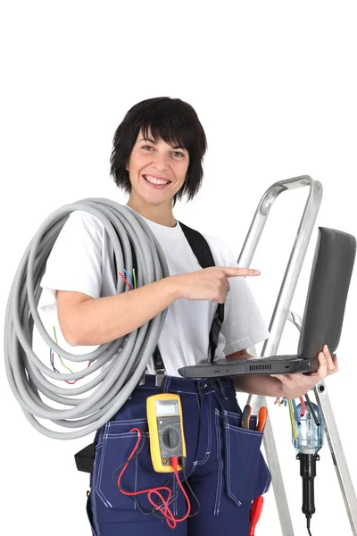 Eletricista feminina com laptop e voltímetro — Fotografia de Stock