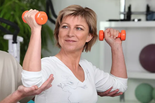 Frau mit orangefarbenen Gewichten — Stockfoto