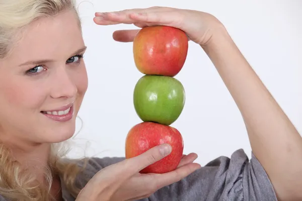 Junge Blondine mit einem Haufen Äpfel — Stockfoto