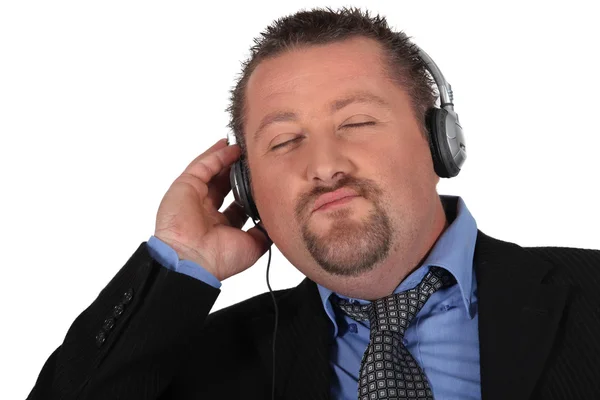 Businessman listening to music on white background — Stock Photo, Image