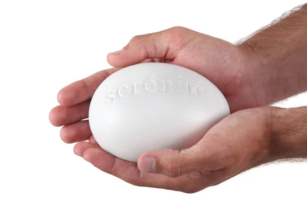 Hands holding a stone marked 'serenite' — Stock Fotó