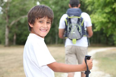 Father and son walking in the woods clipart