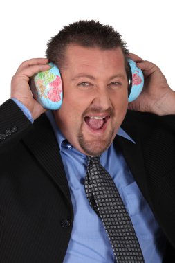 Businessman listening the sound of the world clipart