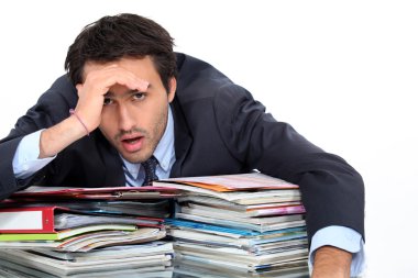 Stressed man under lots of pressure at work clipart