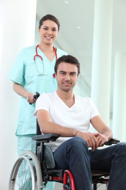 Nurse with disabled man in a wheelchair clipart