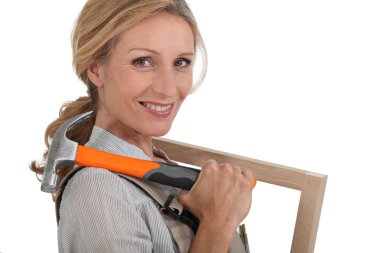 Woman with a picture frame and hammer. clipart