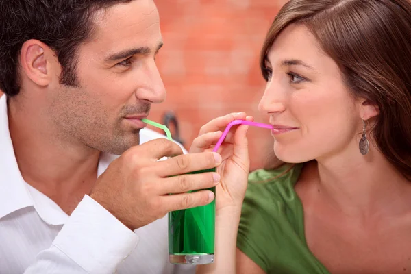 Couple drinking from the same glass — Stock Photo, Image