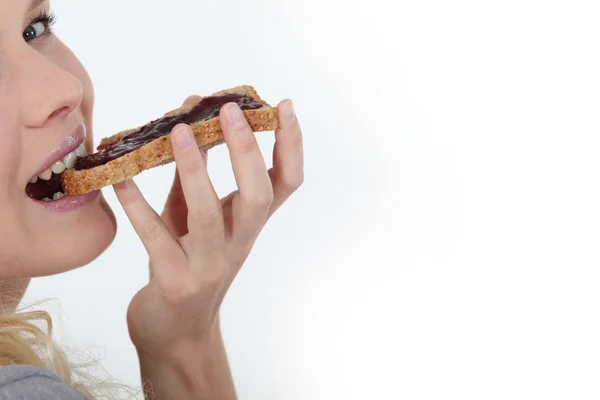 Mujer comiendo mermelada en tostadas —  Fotos de Stock