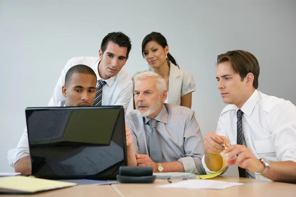 Equipe de negócios sentada em um computador — Fotografia de Stock