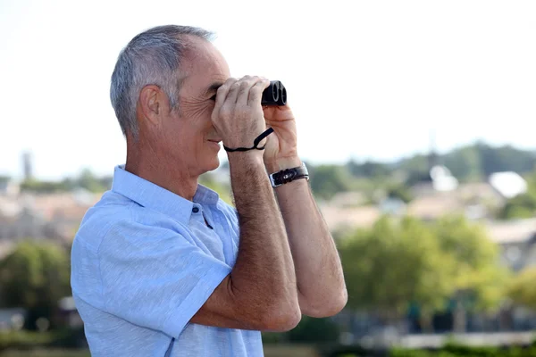 Elderly man with binoculars — Stock Photo, Image