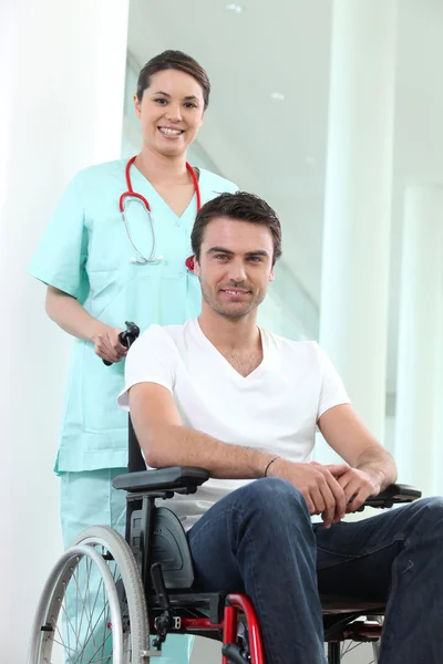 Νοσοκόμα με ανάπηρο άνθρωπο σε μια αναπηρική καρέκλα — Φωτογραφία Αρχείου