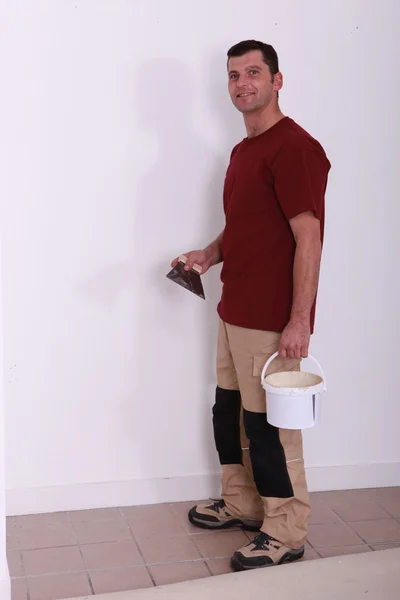 Handyman with a glue pot and a float — Stockfoto