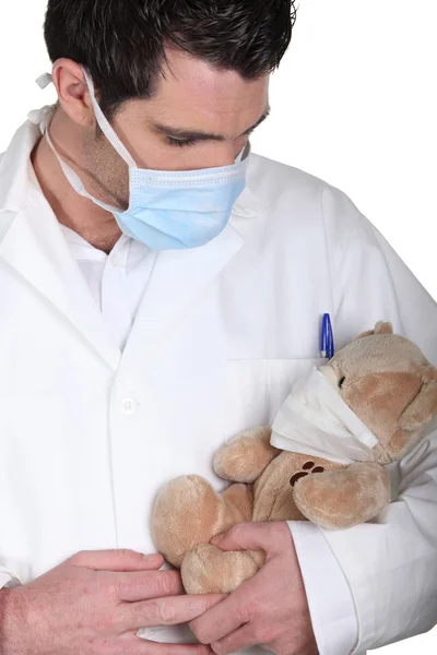 Доктор доглядає за хворим плюшевим ведмедем у масці — стокове фото