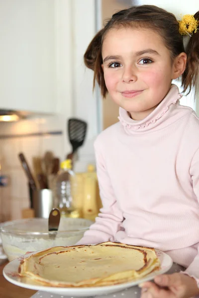 Маленькая девочка держит тарелку блинчиков — стоковое фото