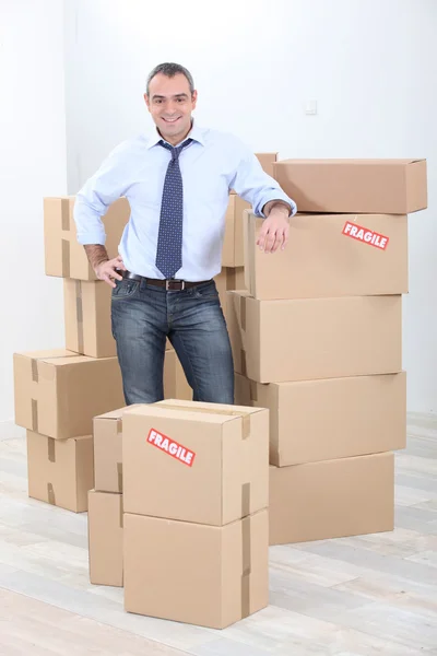 Imagem horizontal de um homem rodeado de papelão — Fotografia de Stock