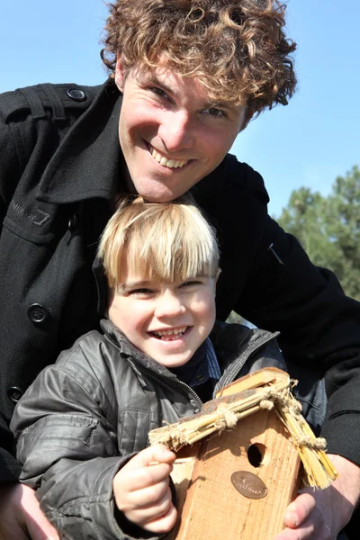 Father and son stood with birdhouse — Stock Photo, Image