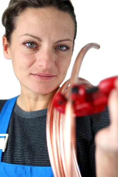 Vrouw snijden koperen pijp — Stockfoto