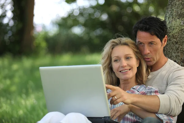 Couple avec ordinateur dans le jardin — Photo