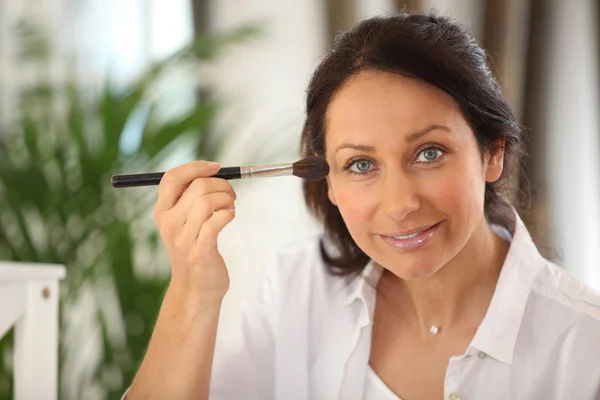 Mujer con un cepillo de maquillaje —  Fotos de Stock