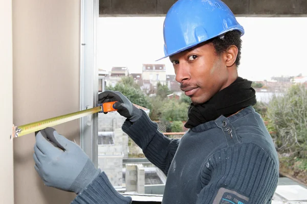 Trabalhador manual que mede a parede interior — Fotografia de Stock